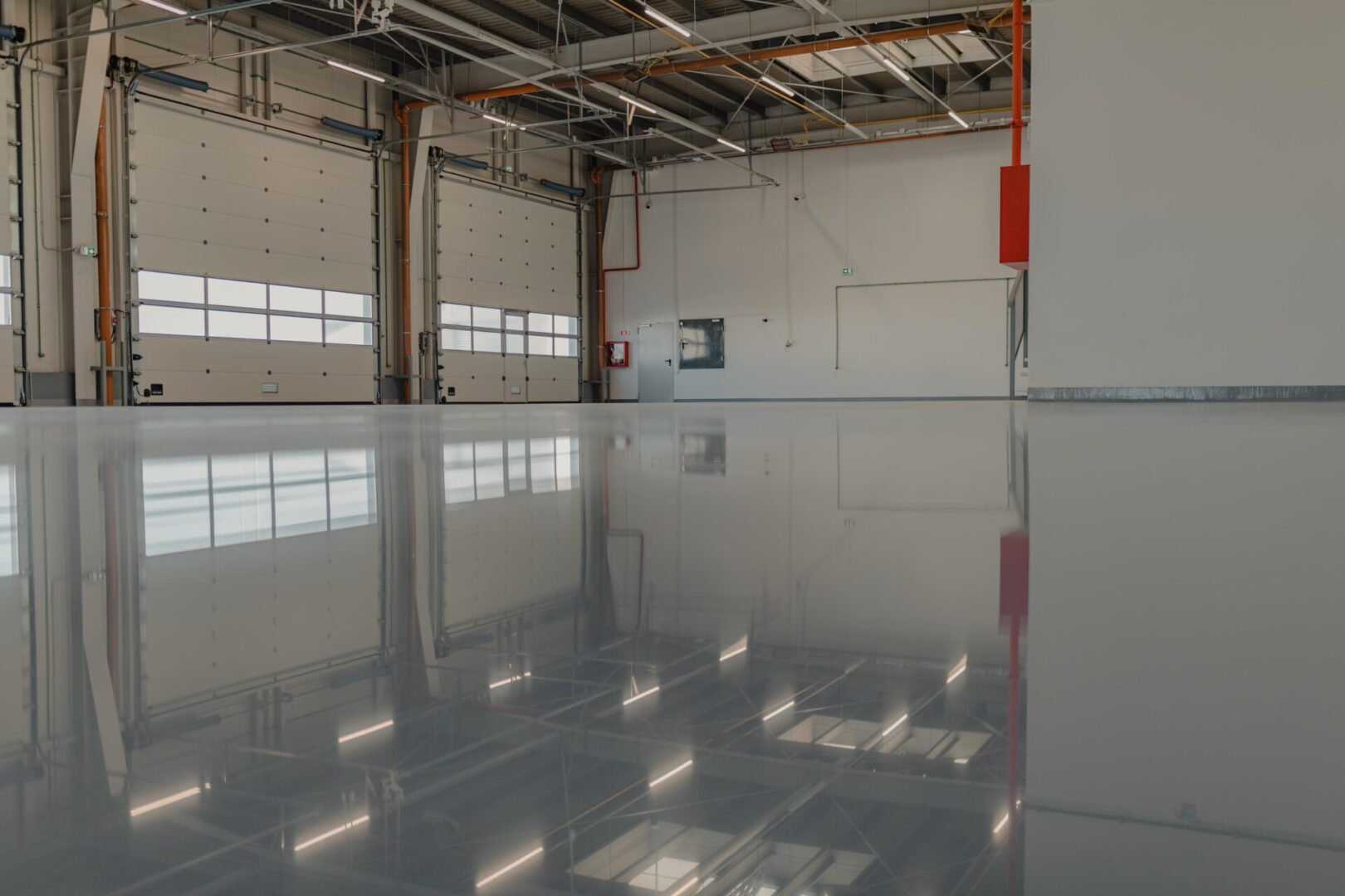 Reflective floor in large empty warehouse.