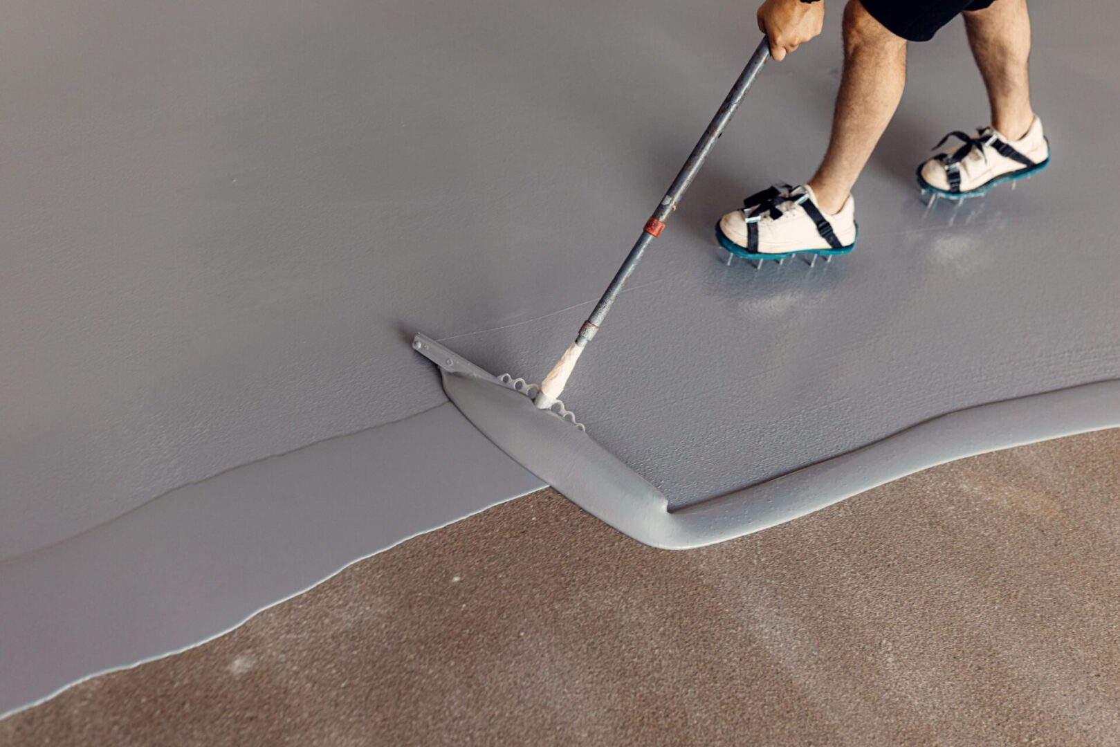 Person applying epoxy floor coating.