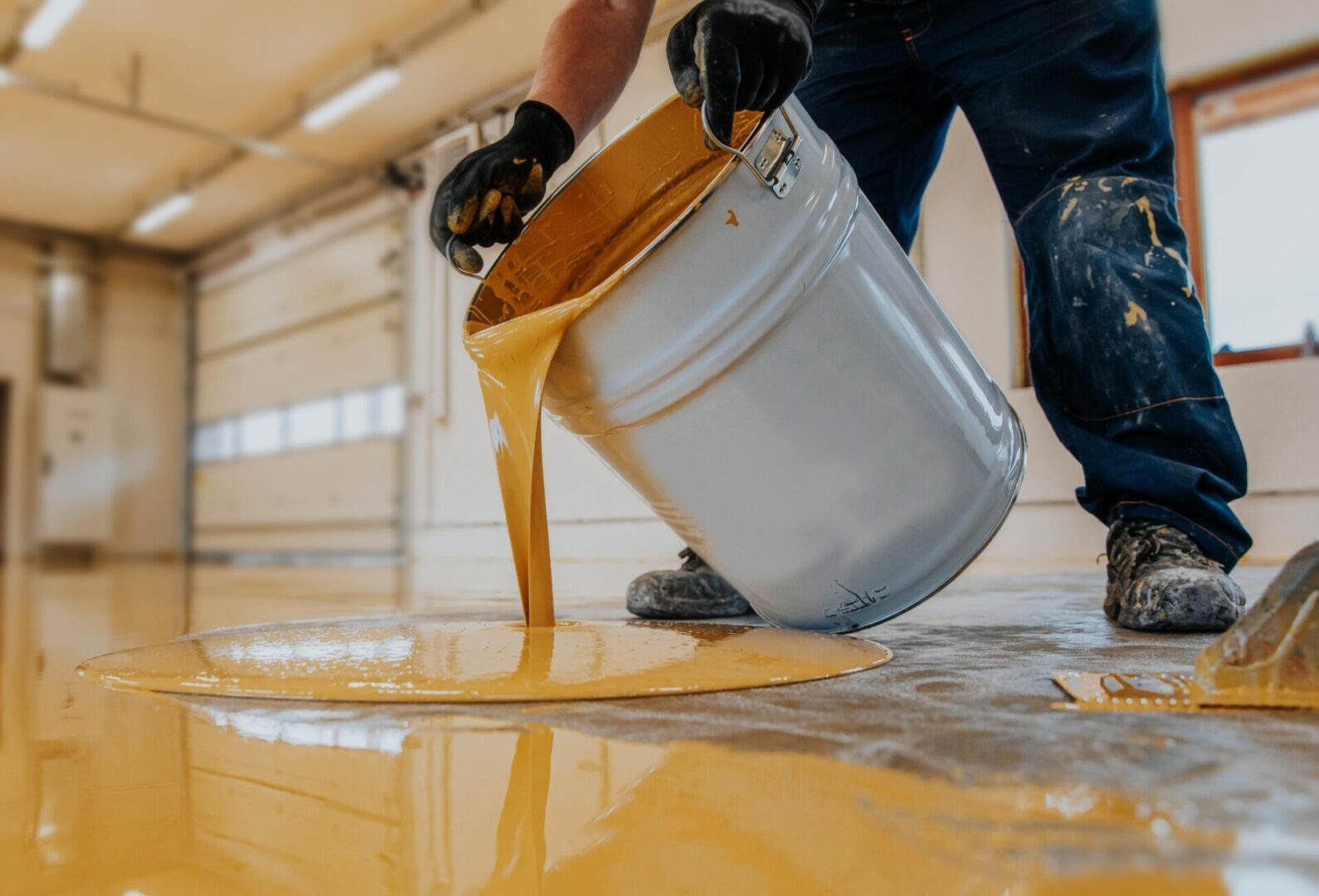 Pouring epoxy floor coating.