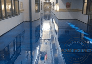 Here's an alt tag for the image: Shiny epoxy flooring in a building hallway.