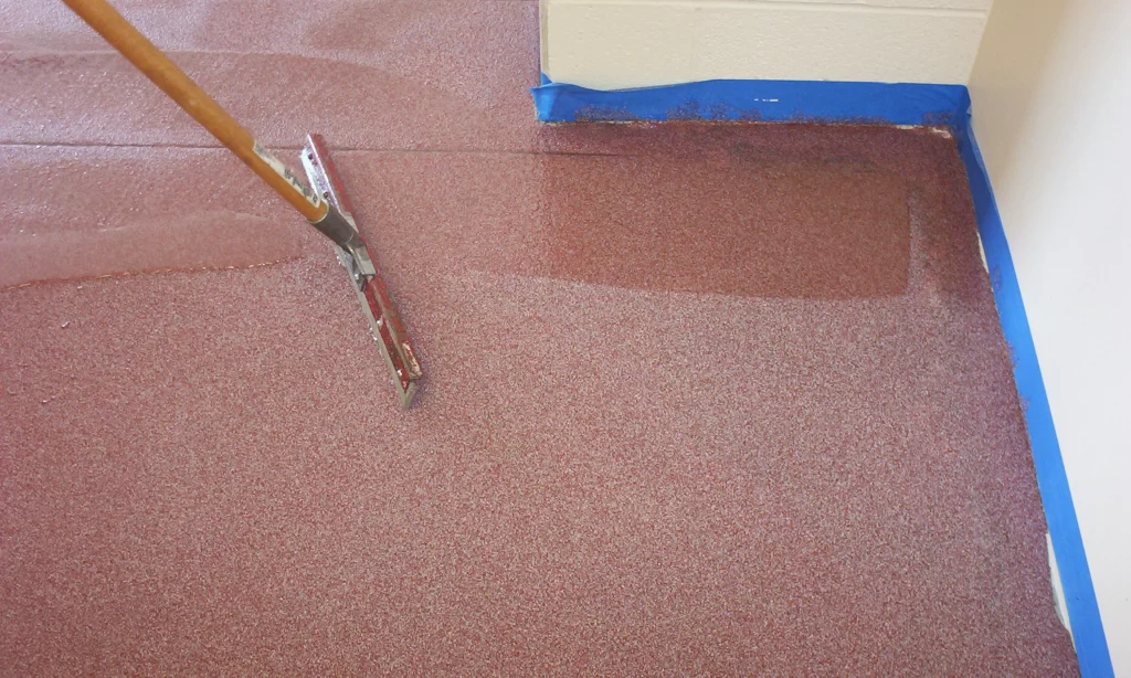 A pair of scissors and paint brush on the floor.